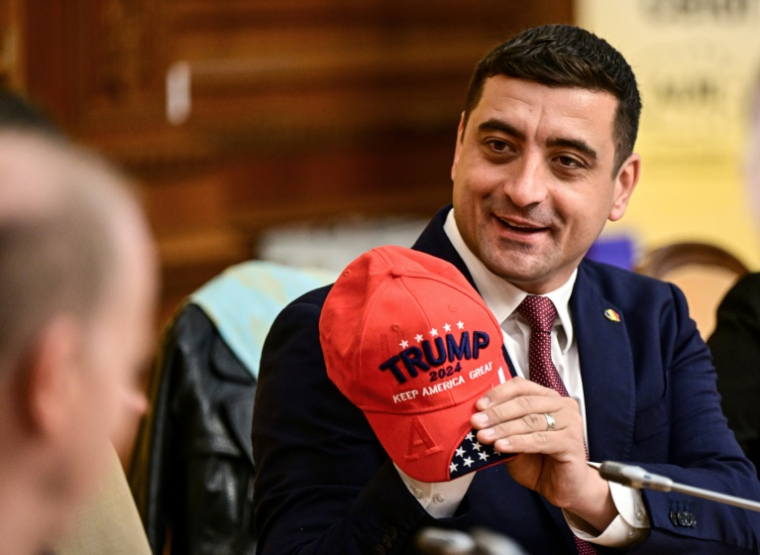 Le chef du parti d'extrême droite roumain AUR, George Simion, casquette rouge en hommage à Donald Trump à la main, le 15 novembre au Parlement de Bucarest ( AFP / Daniel MIHAILESCU )
