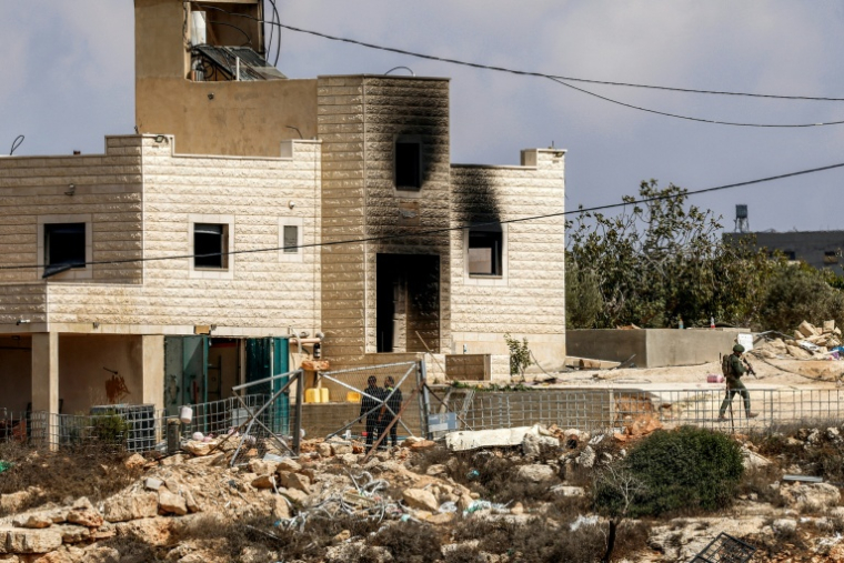 Des forces de sécurité et des colons israéliens devant la maison d'une famille palestinienne, dans le village de Jalud, en Cisjordanie, le 29 septembre 2026 ( AFP / Zain JAAFAR )