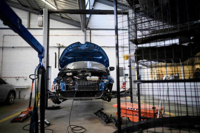 Cette photographie montre une voiture électrique, au e-garage Revolte spécialisé dans la réparation de voitures électriques, à Carquefou, dans l'ouest de la France, le 30 novembre 2022.  ( AFP / LOIC VENANCE )