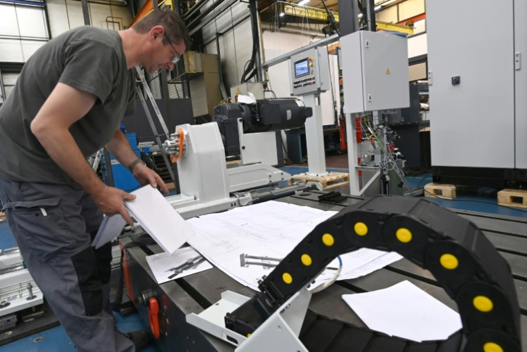 Un employé assemble une machine entièrement conçue par le bureau d'études de l'usine Redex, avant son expédition, à Ferrières-en-Gâtinais, le 18 juin 2025 dans le Loiret ( AFP / JEAN-FRANCOIS MONIER )