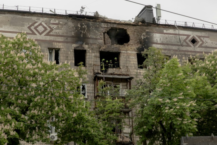 Des sauveteurs ukrainiens inspectent un immeuble résidentiel endommagé par une frappe de drone russe à Kiev, le 7 mai 2025 ( AFP / Roman PILIPEY )