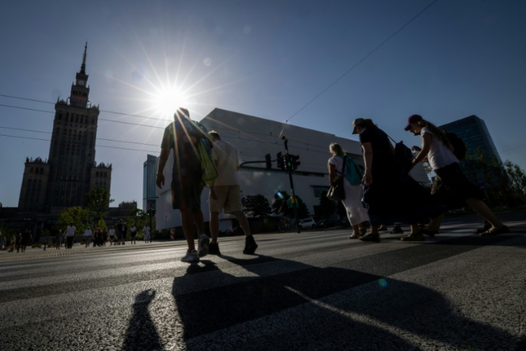Des piétons dans une rue de Varsovie, le 27 juin 2026 en Pologne, lors d'une vague de chaleur en Europe ( AFP / Wojtek RADWANSKI )