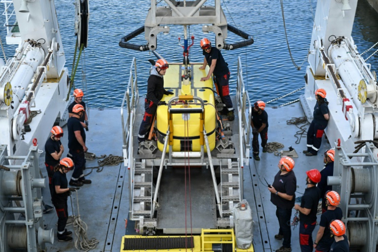 Des techniciens effectuent un test de lancement du robot sous-marin Ulyx à bord du navire scientifique Atalante amarré au port de Brest avant son départ, le 15 juin 2025 dans le Finistère ( AFP / Sebastien Salom-Gomis )