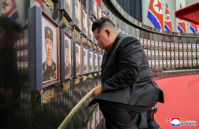 Photo non datée publiée par l'agence de presse officielle nord-coréenne KCNA, le 22 août 2025, du dirigeant nord-coréen Kim Jong-un agenouillé devant des portraits de soldats morts au combat pour la Russie contre l'Ukraine, lors d'une cérémonie au siège du Parti des travailleurs de Corée à Pyongyang ( KCNA VIA KNS / STR )