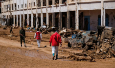 Des membres du Croissant Rouge marchent parmi des décombres à Derna en Libye