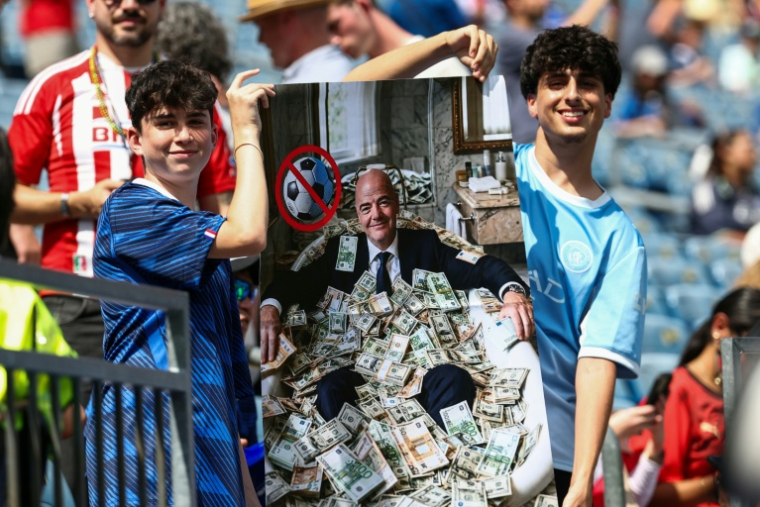 Des supporters présentent une affiche représentant le président de la Fifa, Gianni Infantino, dans une baignoire de billets, lors du quart de finale du Mondial-2026 entre la France et le Maroc à Foxborough, le 9 juillet 2026 ( AFP / FRANCK FIFE )