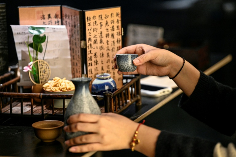 Helen Zhao tient un cocktail inspiré  de la médecine traditionnelle chinoise dans un bar à Shanghai, le 3 février 2026 en Chine ( AFP / Jade GAO )