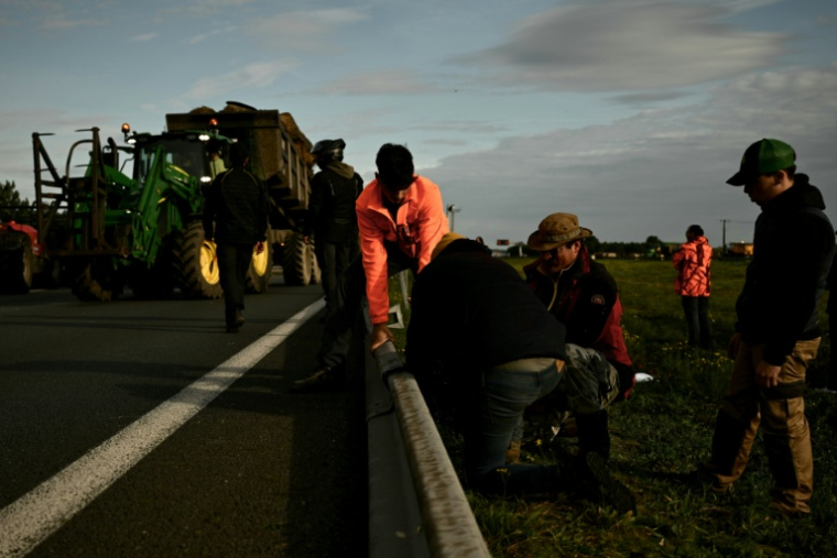 Des agriculteurs démontent des barrières métalliques le long de l'autoroute A63 bloquée au niveau de l'échangeur de Cestas, en Gironde, le 16 décembre 2020 ( AFP / Philippe LOPEZ )