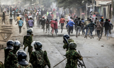 Des manifestants se mettent l'abri lors d'affrontements avec des policiers au cours d'une manifestation contre un centre de quarantaine Ebola construit par les États-Unis sur la base aérienne de Laikipia, le 9 juin 2026 à Nanyuki, au Kenya ( AFP / Luis TATO )