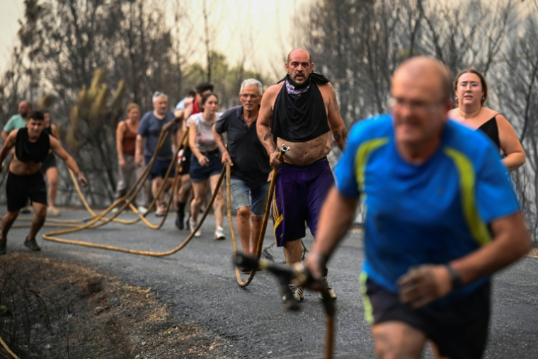 Des personnes tentent d'éteindre l'incendie à Larouco, dans le nord-ouest de l'Espagne, le 13 août 2025 ( AFP / MIGUEL RIOPA )