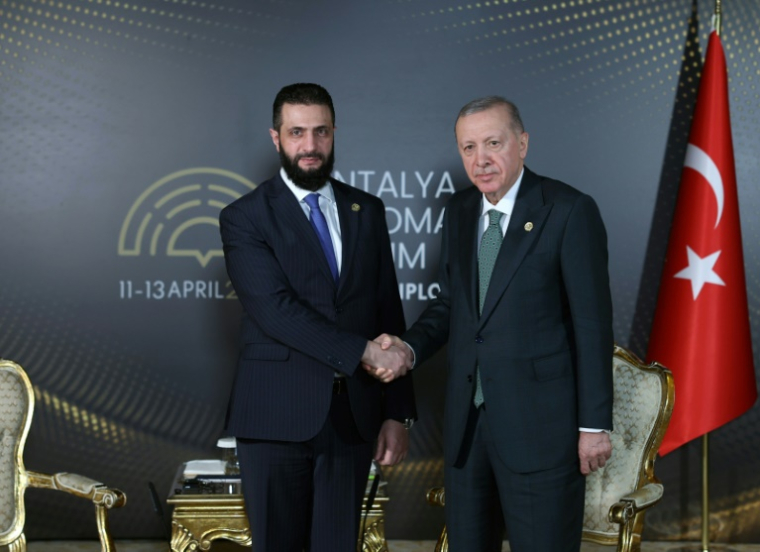 This handout photograph taken and released by Turkish Presidency Press Office on April 11, 2025, shows Photo diffusée par le service de presse de la présidence turque, le 11 avril 2025, montrant le président turc Recep Tayyip Erdogan et le président syrien par intérim, Ahmad al-Chareh (g) lors du Forum diplomatique d'Antalya, dans le sud de la Turquie ( Service de presse de la présidence turque / Handout )