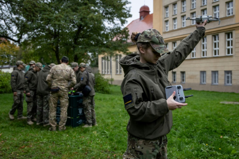 Une élève d'une école militaire polonaise se forme à l'usage de drones à l'extérieur de l'établissement, à Legnica le 8 octobre 2025 ( AFP / Wojtek RADWANSKI )