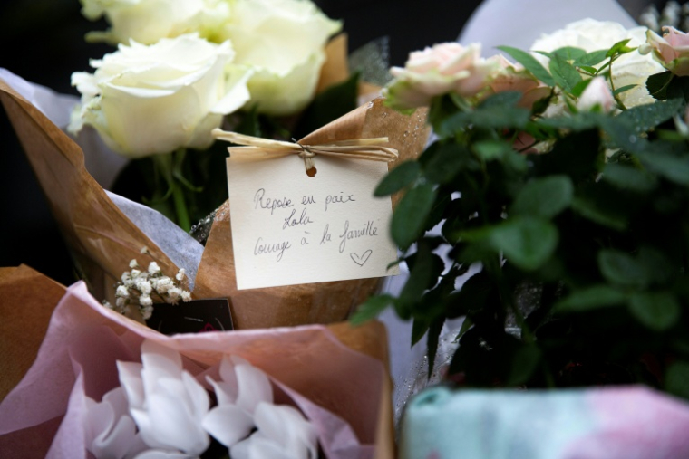 Des fleurs et des messages déposés devant l'immeuble où habitait Lola, le 17 octobre 2022 à Paris ( AFP / STRINGER )