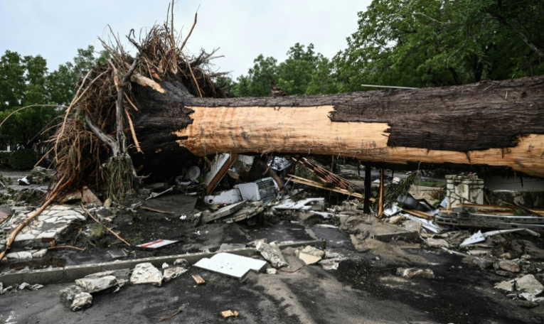 Un arbre arraché devant le camp d'été pour filles dont une trentaine sont portées disparues à la suite des inondations provoquées par la crue du fleuve Guadalupe, au Texas, à Kerrville, aux Etats-Unis, le 5 juillet 2025 ( AFP / RONALDO SCHEMIDT )