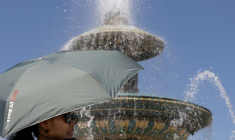 Une femme se protège du soleil avec un parapluie le 27 mai 2026 à Paris ( AFP / JOEL SAGET )