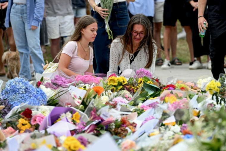 Des personnes se se recueillent devant le Bondi Pavillion, en mémoire des victimes de la fusillade de la plage de Bondi, à Sydney, le 15 décembre 2025 en Australie ( AFP / Saeed KHAN )
