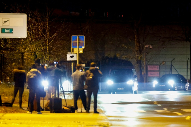 Des journalistes filment un convoi transportant l'écrivain franco-algérien Boualem Sansal, quittant l'aéroport de Berlin à Schönefeld, le 12 novembre 2025 ( AFP / Odd ANDERSEN )