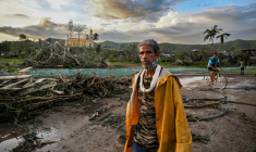 Un habitant d'El Cobre, dans la province de Santiago de Cuba marche devant des arbres et des lignes électriques tombés à terre après le passage de l'ouragan Melissa dans le sud-est de Cuba, le 29 octobre 2025 ( AFP / YAMIL LAGE )