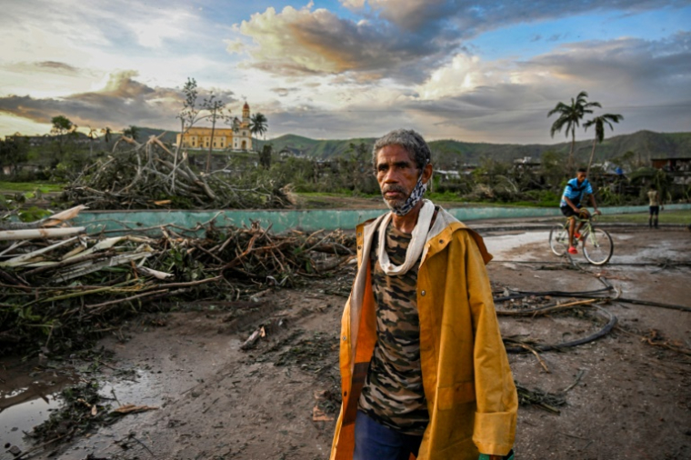 Un habitant d'El Cobre, dans la province de Santiago de Cuba marche devant des arbres et des lignes électriques tombés à terre après le passage de l'ouragan Melissa dans le sud-est de Cuba, le 29 octobre 2025 ( AFP / YAMIL LAGE )