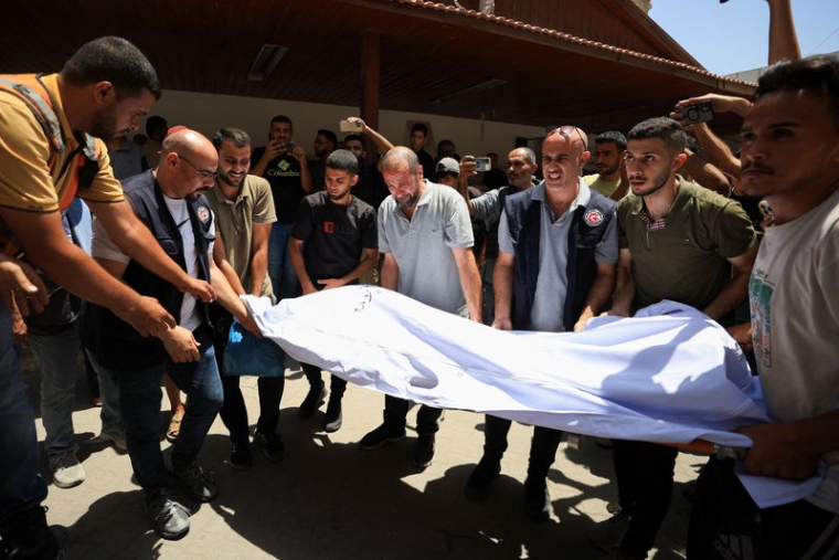 Des personnes transportent le corps du chrétien palestinien Saad Salama, tué dans une frappe israélienne sur l'église de la Sainte-Famille