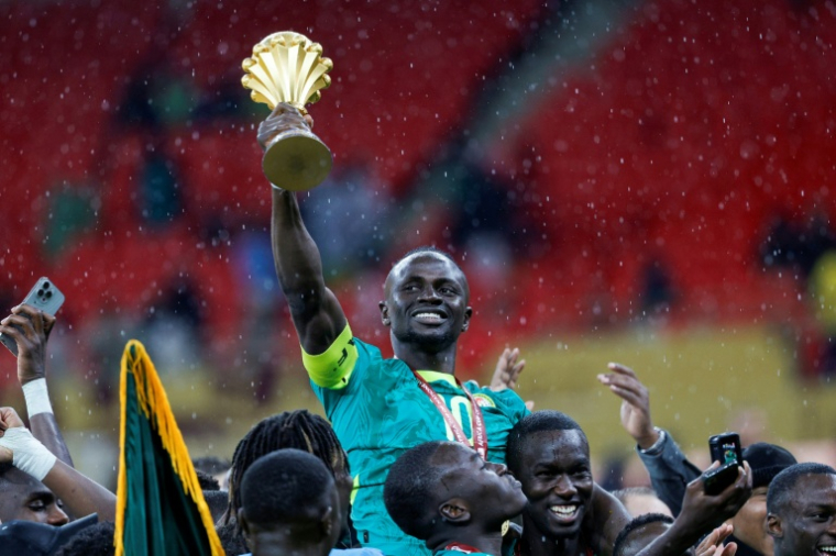 Un des héros de la finale de la CAN, la star sénégalaise Sadio Mané, brandit le trophée de champion d'Afrique, le 18 janvier 2026 à Rabat ( AFP / Abdel Majid BZIOUAT )