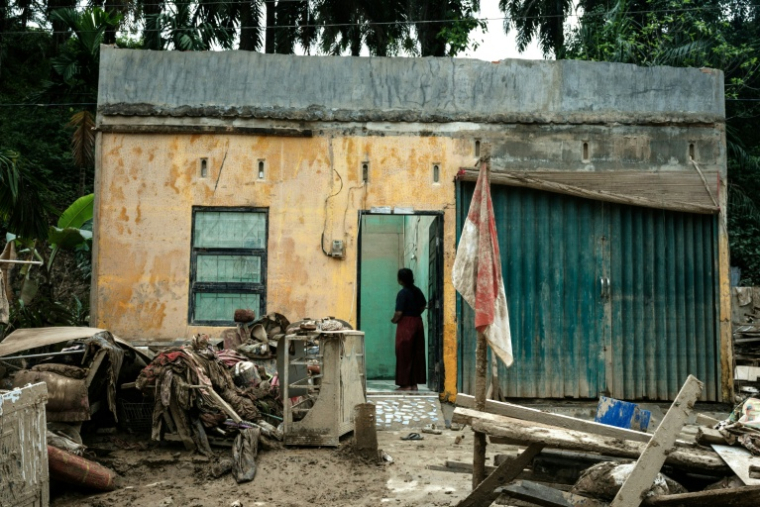 Une femme devant une maison endommagée par les inondations à Babo, Aceh Tamiang, dans le nord de Sumatra, le 15 décembre 2025 ( AFP / Yasuyoshi CHIBA )