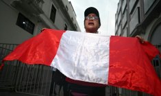 Une femme brandissant un drapeau péruvien proteste devant les locaux de l’Office national des processus électoraux (ONPE), à Lima, le 13 avril 2026 ( AFP / ERNESTO BENAVIDES )