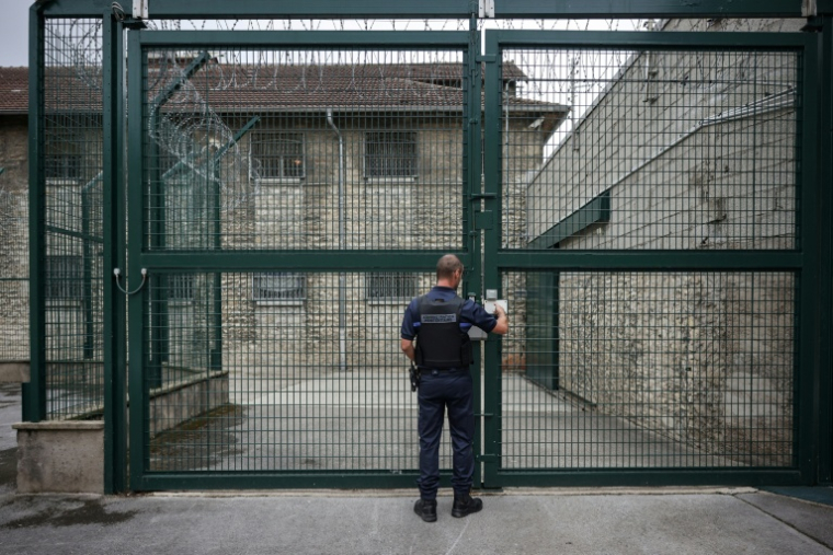 Un gardien devant une grille d'accès à la prison de Besançon, le 13 septembre 2023 ( AFP / ARNAUD FINISTRE )