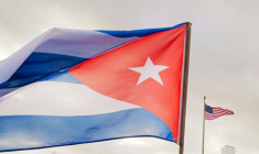 Un soldat cubain brandit un drapeau national alors qu’il participe à la manifestation "anti-impérialiste" devant l’ambassade des États-Unis contre l’incursion américaine au Venezuela, à La Havane, le 16 janvier 2026. ( AFP / ADALBERTO ROQUE )