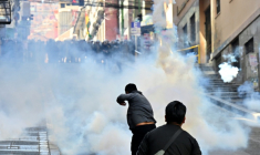 Des policiers antiémeutes lancent des grenades lacrymogènes sur des manifestants lors d'une protestation réclamant la démission du président bolivien Rodrigo Paz, le 18 mai 2026 à La Paz ( AFP / Aizar RALDES )