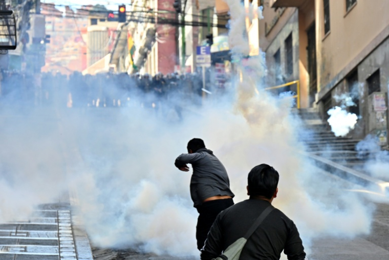 Des policiers antiémeutes lancent des grenades lacrymogènes sur des manifestants lors d'une protestation réclamant la démission du président bolivien Rodrigo Paz, le 18 mai 2026 à La Paz ( AFP / Aizar RALDES )