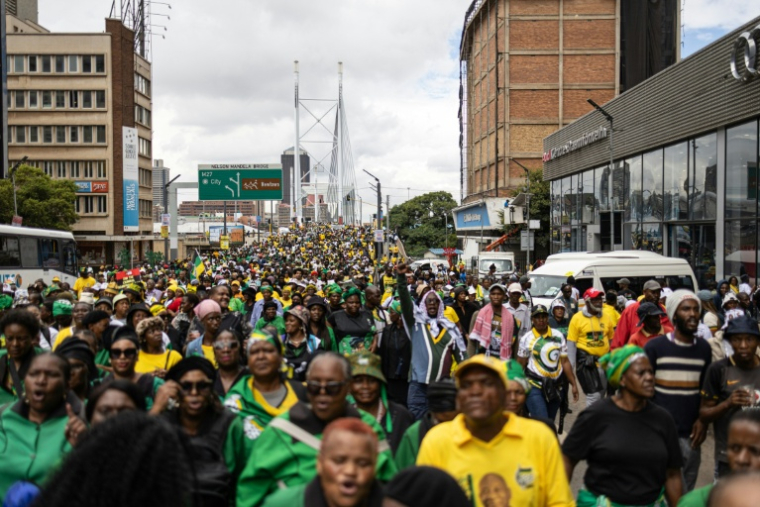 Des milliers de manifestants, appelés à défiler par l'ANC, traversent l'emblématique pont Nelson Mandela de Johannesburg le 21 mars 2026. ( AFP / EMMANUEL CROSET )