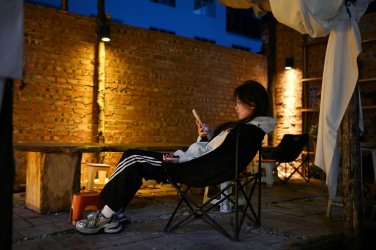 Une jeune femme se repose dans une "maison de retraite pour jeunes" à Dali, dans la province du Yunnan, dans le sud-ouest de la Chine, le 2 avril 2025 ( AFP / GREG BAKER )