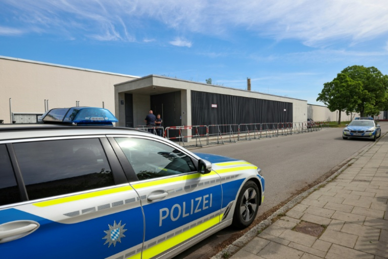 Des véhicules de police sont visibles devant le tribunal lors du procès de trois accusés soupçonnés d'espionnage pour le compte de Moscou et de préparation d'actes de sabotage à Munich, dans le sud de l'Allemagne, le 20 mai 2025 ( AFP / Alexandra BEIER )