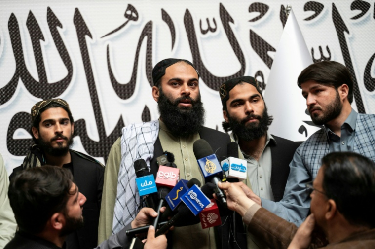 Ibrahim Rahim (c), le fils de Muhammad Rahim, dernier Afghan détenu à la prison de haute sécurité américaine de Guantanamo à Cuba, s'adresse aux médias à l'aéroport de Kaboul, le 24 mars 2026 en Afghanistan ( AFP / Wakil KOHSAR )