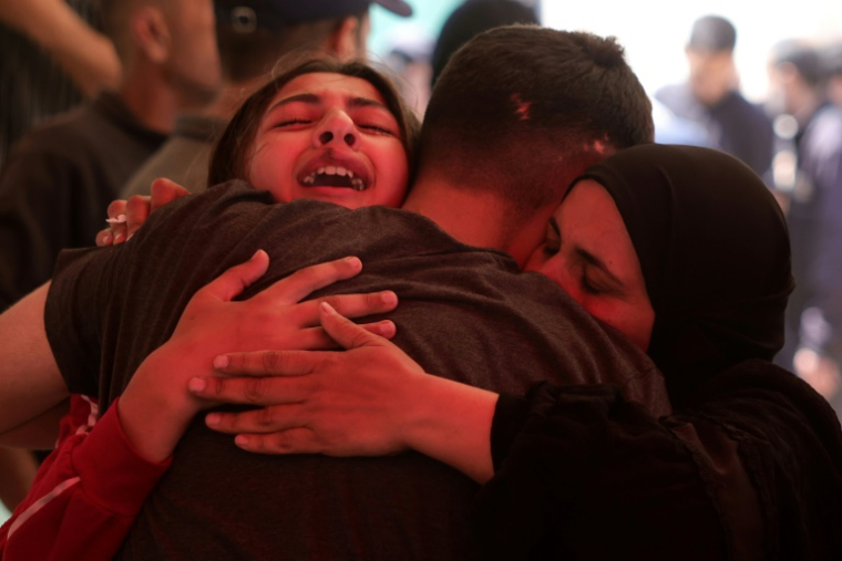 Des Palestiniens se prennent dans les bras à l'hôpital indonésien à Beit Lahia, dans le nord de la bande de Gaza, après la mort de proches dans une frappe israélienne à Jabalia, le 15 mai 2025 ( AFP / BASHAR TALEB )