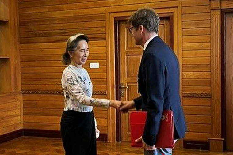 Cette photo, prise et diffusée le 3 août 2026 par le Bureau présidentiel de la presse et de l'information (PPIB) de Birmanie, montre l'ancienne dirigeante Aung San Suu Kyi (à gauche), détenue en résidence surveillée, lors d'un entretien avec Arnaud de Baecque, représentant résident du Comité international de la Croix-Rouge (CICR) en Birmanie, à Naypyidaw. ( Myanmar's Presidential Press and Information Bureau / Handout )