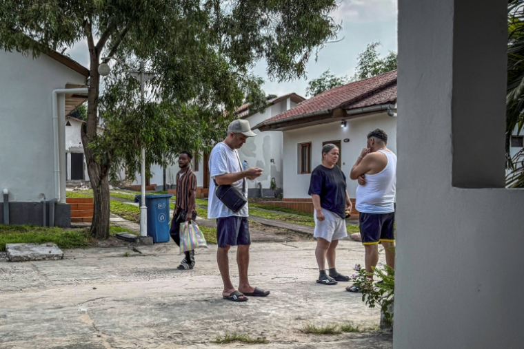 Des migrants expulsés des États-Unis vers la République démocratique du Congo (RDC) se rassemblent pour discuter dans un espace extérieur commun d'un hôtel de Kinshasa, le 22 avril 2026 ( AFP / Glody MURHABAZI )