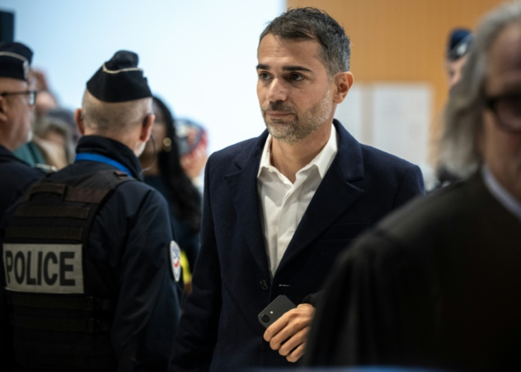 Aurelien Poirson-Atlan, connu sur les réseaux sociaux sous le nom de Zoé Sagan, arrive au tribunal de Paris pour son procès avec neuf autres personnes accusées de cyberharcèlement sexiste à l'encontre de Brigitte Macron, le 27 octobre 2025 ( AFP / Guillaume BAPTISTE )