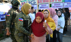 Des femmes venues voter sont fouillées avant d'entrer dans un bureau de vote à Marawi, le 14 septembre 2026, aux Philippines ( AFP / Ted ALJIBE )