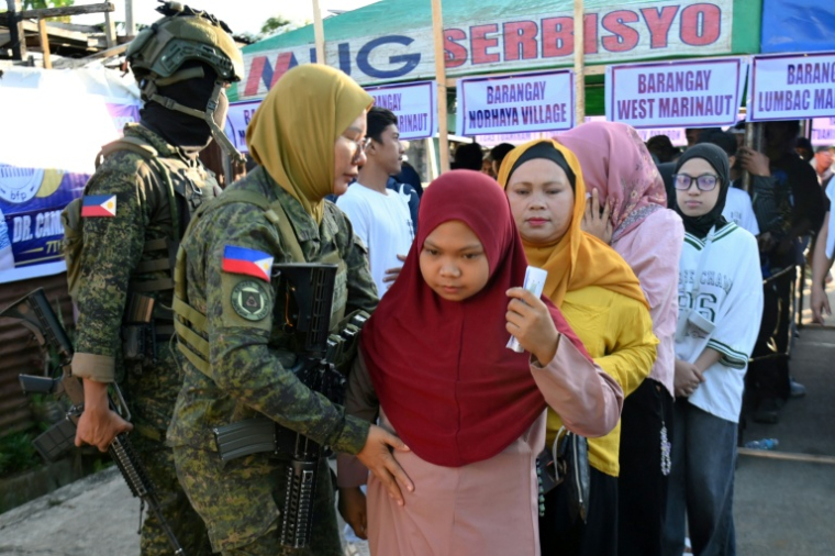 Des femmes venues voter sont fouillées avant d'entrer dans un bureau de vote à Marawi, le 14 septembre 2026, aux Philippines ( AFP / Ted ALJIBE )