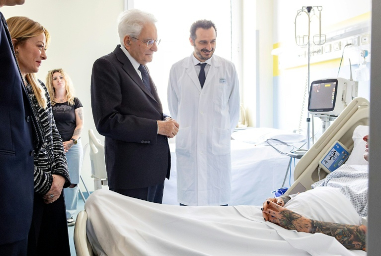 Photo publiée par les services de la présidence italienne montrant le président Sergio Mattarella (C) et la présidente du Conseil Giorgia Meloni (G) au chevet d'une des victimes renversées par un conducteur ayant des antécédents psychiatriques, le 17 mai 2026 à Modène ( AFP / Paolo Giandotti )