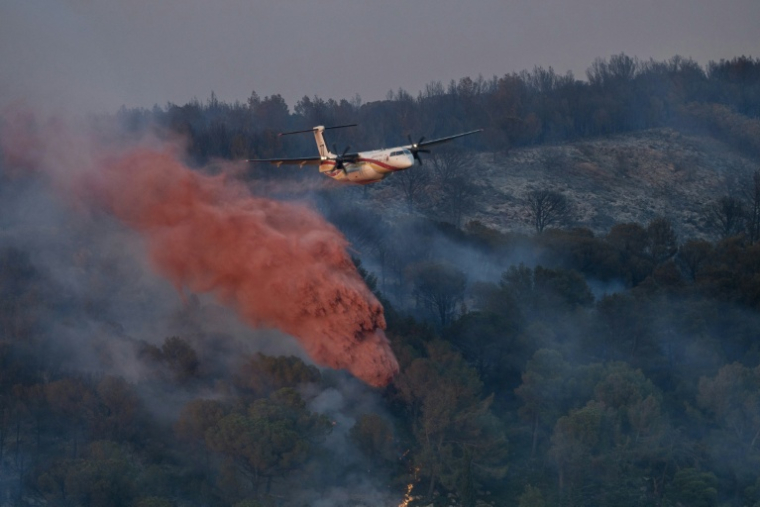Un avion Dash largue du retardant sur les flammes d'un incendie près de Bizanet, le 29 juin 2025 ( AFP / IDRISS BIGOU-GILLES )