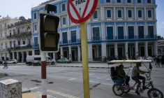 Un vélo-taxi passe devant un feu de signalisation éteint en raison d'une coupure de courant à La Havane, le 4 mars 2026 ( AFP / YAMIL LAGE )