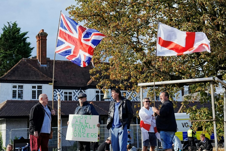 Manifestation devant l'hôtel Bell à Epping, au nord de Londres, après que la cour d'appel a annulé une décision bloquant temporairement l'utilisation de l'établissement pour héberger des demandeurs d'asile, le 29 août 2025 ( AFP / CARLOS JASSO )