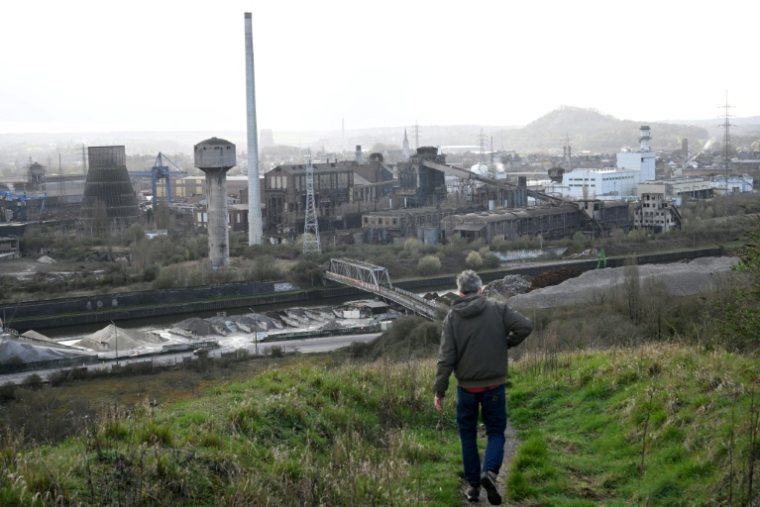 Un visiteur descend un terril près d'aciéries abandonnées à Charleroi, dans le sud de la Belgique, le 11 mars 2026 ( AFP / Nicolas TUCAT )