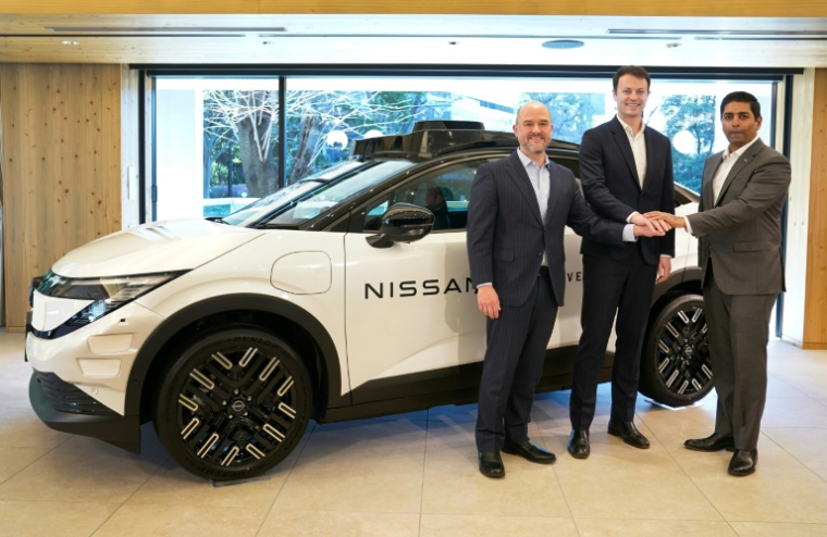 Ivan Espinosa (g), PDG de Nissan Motor, Alex Kendall (c), PDG de Wayve Technologies, et Sarfraz Maredia (d), de chez Uber Technologies, devant un prototype de véhicule à Tokyo le 12 mars 2026 ( AFP / Kazuhiro NOGI )