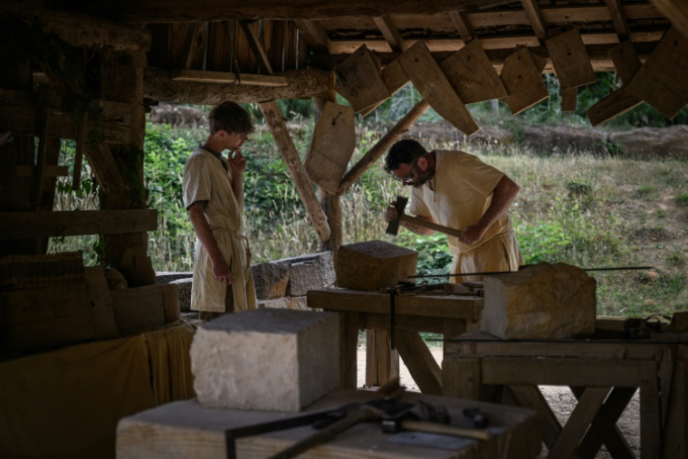 Des tailleurs de pierre travaillent sur le chantier de construction du château de Guédelon, un château médiéval construit uniquement selon les méthodes du XIIIe siècle, à Treigny, le 23 juin 2025 dans l'Yonne ( AFP / ARNAUD FINISTRE )
