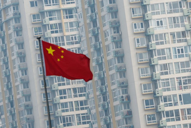 Un drapeau national chinois flotte près d'immeubles résidentiels à Pékin