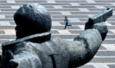 Un garçon court près d'un monument sur une place où se situe le musée national de l'histoire de l'Ukraine dans la Seconde guerre mondiale, le 9 mai 2026 à Kiev ( AFP / Sergei SUPINSKY )